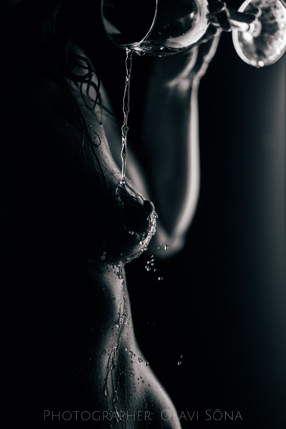 Pouring water on a boob. Nude art.